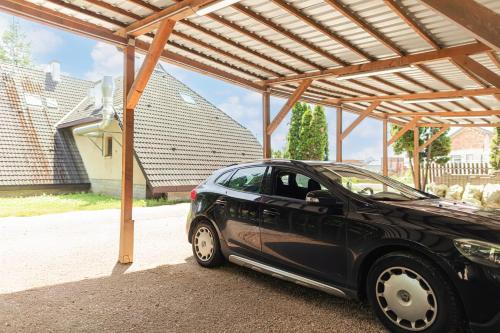a black car parked under a pergola at Charlie Vendégház in Sé