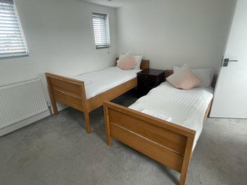 two twin beds in a room with two windows at Blue House in Stone Grove