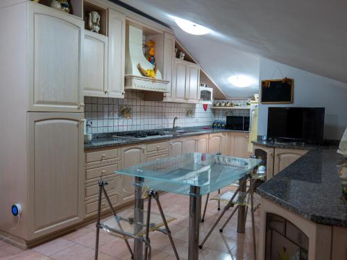 a kitchen with white cabinets and a blue counter top at "Da Remo" in Mògoro