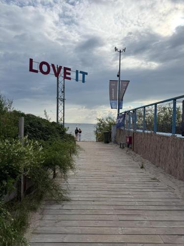 a boardwalk with a sign that reads love it at Fun Like Hel Kite&Wind in Jastarnia