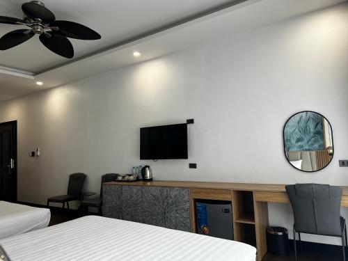 a hotel room with two beds and a flat screen tv at Dawn Boutique Luangprabang Hotel in Luang Prabang
