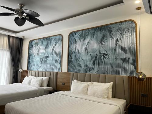 a bedroom with two beds and a ceiling fan at Dawn Boutique Luangprabang Hotel in Luang Prabang