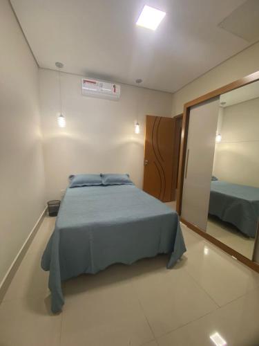 a bedroom with a blue bed and a mirror at Royal Lion Bedroom in Londrina