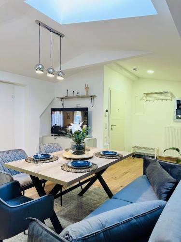 a living room with a table and blue chairs at Modern Holiday Apartment in Anklam - Next to City Center in Anklam