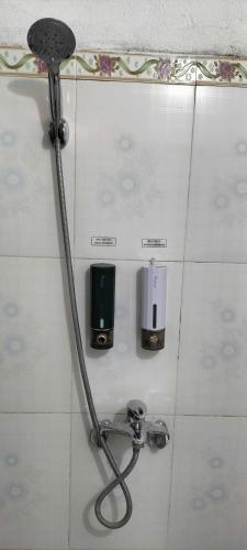 a shower in a bathroom with a hose on the wall at Nam Pé Tày Homestay - View hồ Ba Bể in Bak Kan