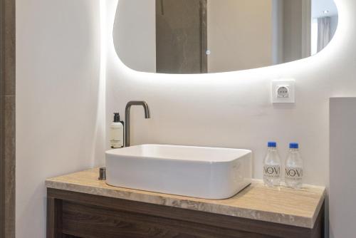 a bathroom with a white sink and a mirror at Boutique hotel Novi in Zandvoort