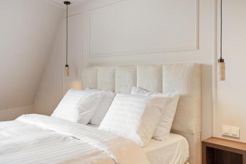 a white bed with white pillows in a bedroom at Boutique hotel Novi in Zandvoort