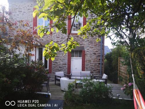 a patio with white furniture in front of a building at chambres dans Maison individuelle 46 Rue de Luzel in Saint-Brieuc