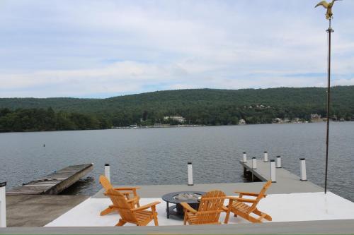 a dock with chairs and a table on the water at Lakefront Haven on Greenwood Lake in Hewitt