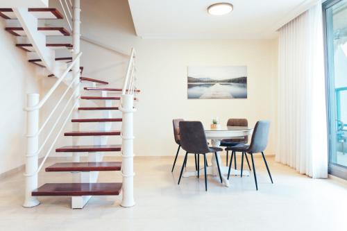 a dining room with a staircase and a table and chairs at Luxury Penthouses with Jacuzzi for 8 people on the beach by Almog Beach Haifa Apartments in Haifa