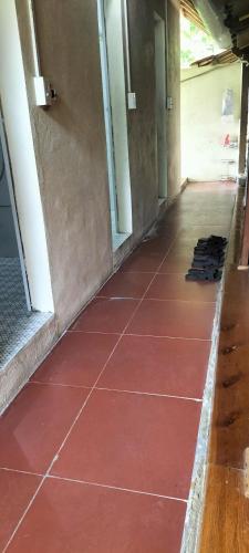 an empty hallway with red tiles on the floor at Nam Pé Tày Homestay - View hồ Ba Bể in Bak Kan