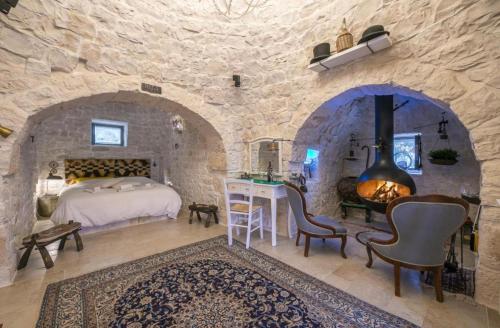 a bedroom with a bed and a fireplace in a stone wall at RebeaTrulliHome with Pool Fasano in Fasano