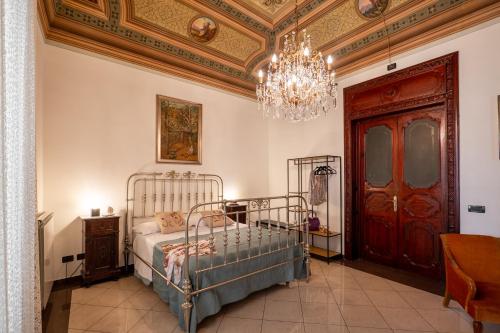a bedroom with a bed and a chandelier at Artista Apartment in Alcamo