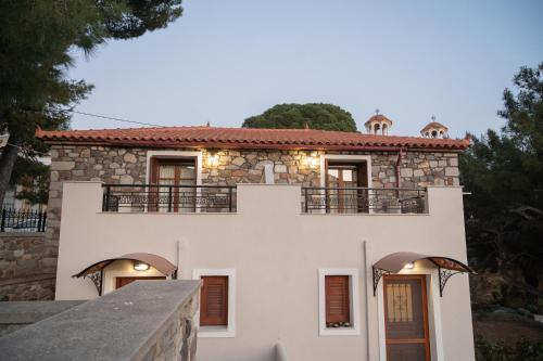 a large white house with a stone facade at Galinos traditional house A in Eresos