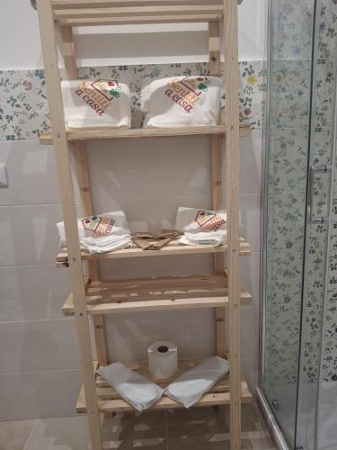 a wooden shelf with towels on it in a bathroom at Sentiti a casa in Bronte