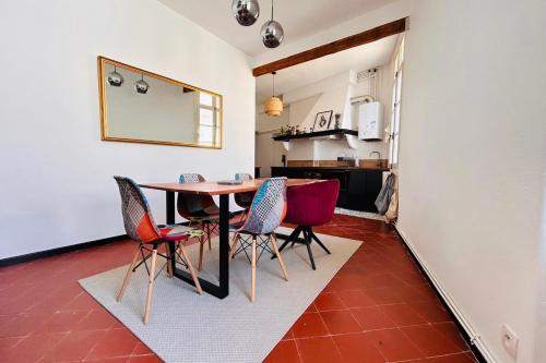 une cuisine et une salle à manger avec une table et des chaises dans l'établissement La Loge Cœur de Ville WIFI, à Perpignan