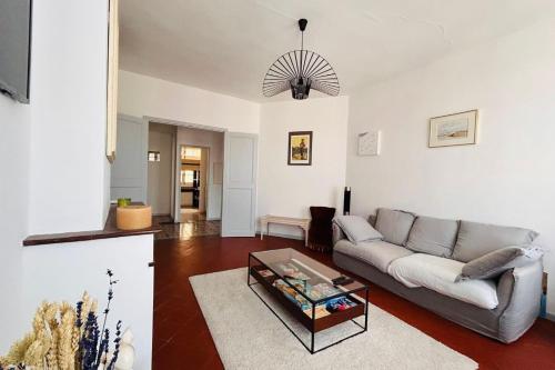 un salon avec un canapé et une table dans l'établissement La Loge Cœur de Ville WIFI, à Perpignan