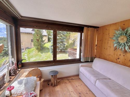 a living room with a couch and a large window at Chesa Flurigna - Zuoz in Zuoz