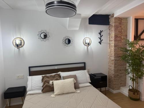 a bedroom with a bed with pillows on it at Apartamentos BocairentHomes, en pleno centro de Bocairent, con pequeña piscina y parking privado in Bocairent