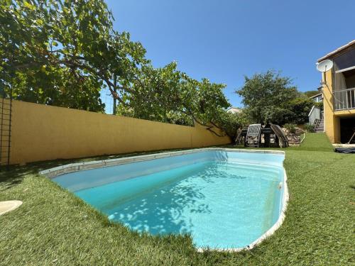 une piscine dans l'herbe à côté d'une maison dans l'établissement Maison Montpellier Nord 10 personnes, à Montpellier