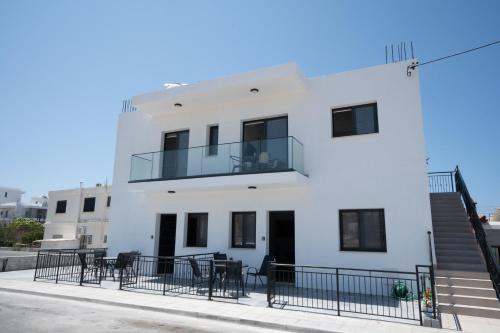 a white building with black chairs in front of it at ARMA CIELO II, 1-bed Cosy Flat in Paphos City