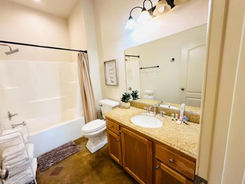 ein Badezimmer mit Waschbecken, Toilette und Spiegel in der Unterkunft Villa 7 in Hammond
