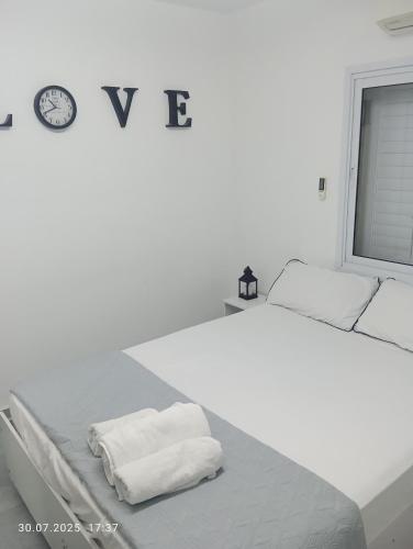 a white bedroom with a bed with towels on it at רימון יחידות אירוח Vacation units RIMON in Ashqelon
