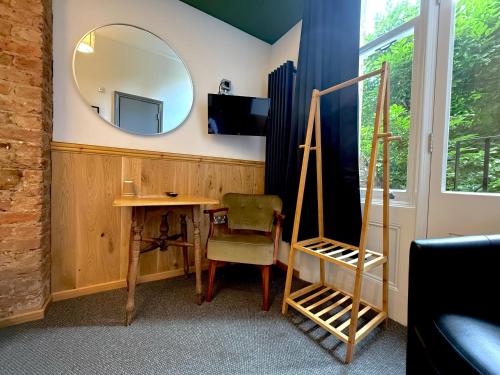a room with a mirror and a desk and a chair at London Visitors Hotel in London