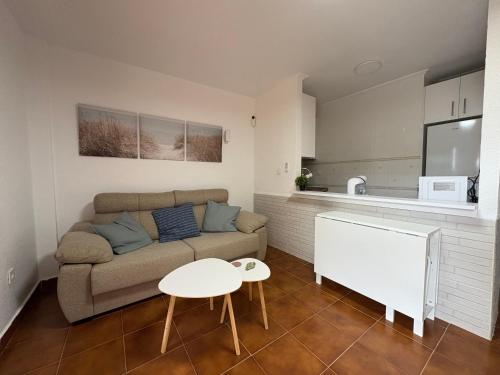 a living room with a couch and a table at Apartamento Oasis Alamillo in Puerto de Mazarrón