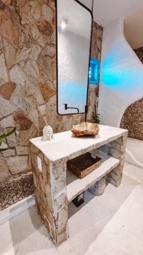 ein Steinbadezimmer mit Waschbecken und Spiegel in der Unterkunft Sollaris in Amontada