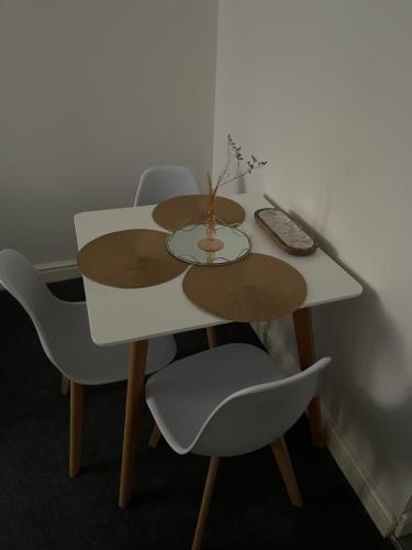 a white table with chairs and a vase on it at Cosy apartment No 2 in Gloucestershire