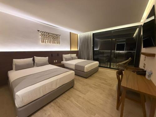 a hotel room with two beds and a desk at Hotel Makkan Boca in Veracruz