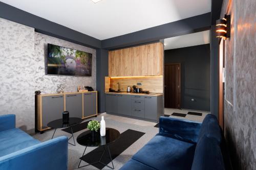 a living room with a blue couch and a table at Nest Suites in Skopje
