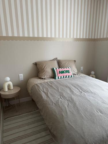 a bed in a bedroom with a striped wall at Le kiosque in Acy-Romance