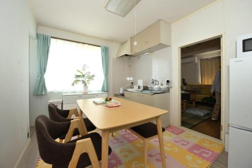 a kitchen with a table and chairs in a room at Stay Chacha 城下町茶茶2F in Marugame