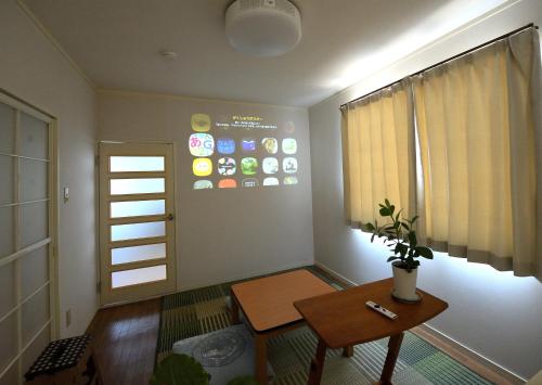 a living room with a table and a window at Stay Chacha 城下町茶茶2F in Marugame