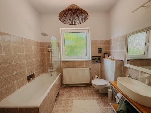 a bathroom with a tub and a toilet and a sink at Casa RusTic in Turda