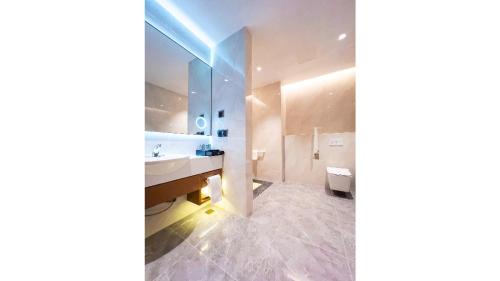 a bathroom with a sink and a mirror at Golden Tulip Kin-Oasis Kinshasa in Kinshasa