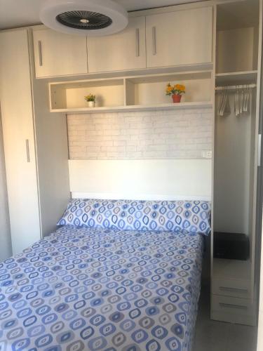 a bedroom with a bed with a blue comforter at Milan Soria Luxury Coblanca XII in Benidorm