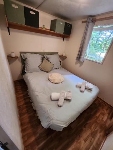 a bed in a small room with towels on it at Mobilhome les pieds dans l eau avec piscine in Saint-Gérons