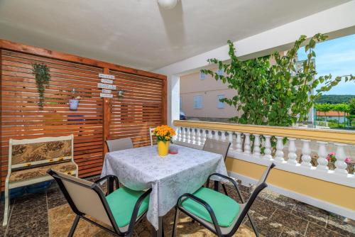 a dining room with a table and chairs on a balcony at Apartments Roby in Kampor