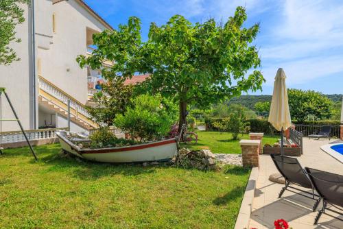 a tree in a boat in the yard of a house at Apartments Roby in Kampor