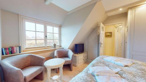 a bedroom with a bed and a chair and a tv at Uep Soel in Kampen