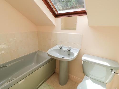 a bathroom with a sink and a toilet and a bath tub at Uplands in Compton