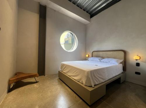 a bedroom with a bed and a round window at Capybara Hostel Boutique - Villavicencio in Villavicencio