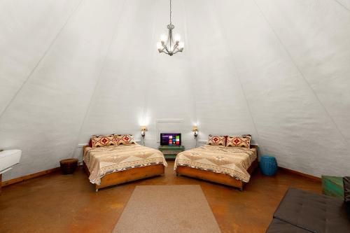 a room with two beds in a tent at Tipis on the Guadalupe in New Braunfels