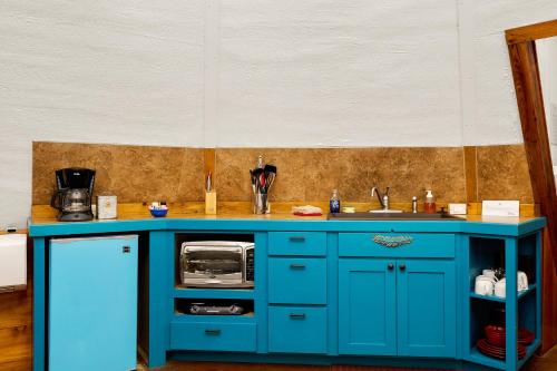 a blue cabinet with a microwave in a kitchen at Tipis on the Guadalupe in New Braunfels
