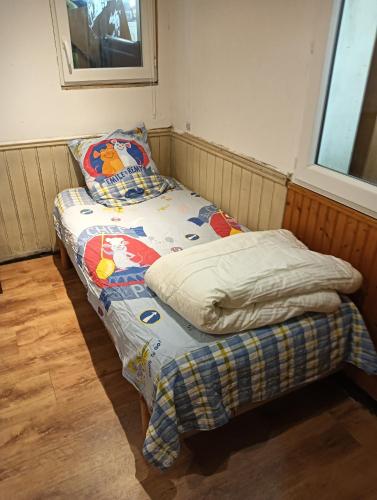 a small bed in a room with a pillow on it at Petite maison dans centre ville in Saumur