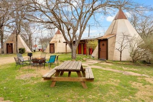 a picnic table in front of a group of tents at Tipis on the Guadalupe in New Braunfels