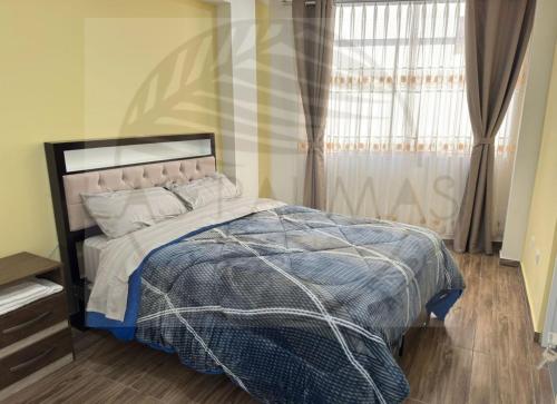 a bedroom with a bed and a window with curtains at Las Palmas Apart in Tacna